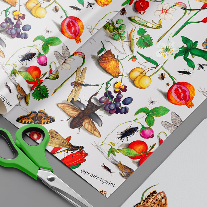 Sheet of nature-themed stickers with fruits, insects, and plants on a white background, accompanied by green scissors.