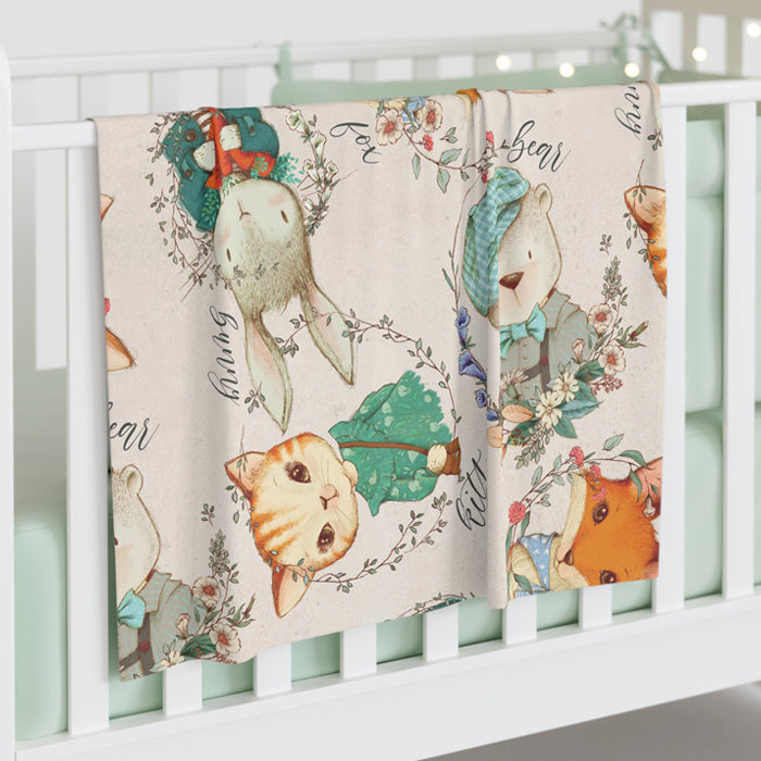 Crib with a decorative blanket featuring animal illustrations on a white crib frame.