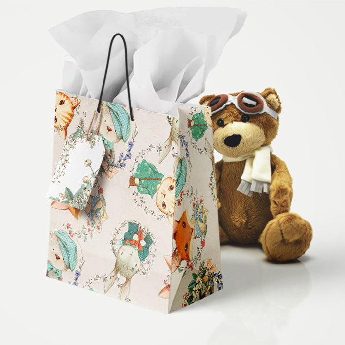 Floral-patterned baby gift bag with a teddy bear wearing goggles and a scarf on a white background