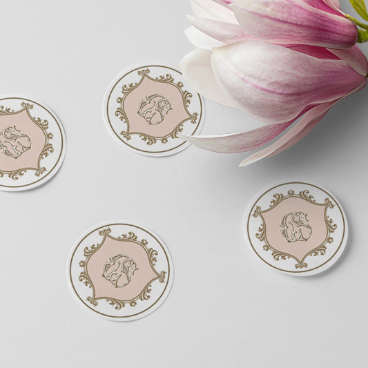 Round decorative stickers with a floral design on a light surface with a pink flower.