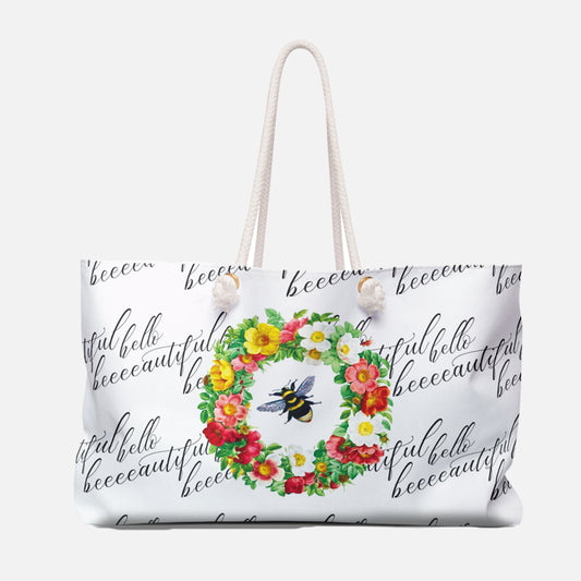 White tote bag with floral wreath and bee design on a white background