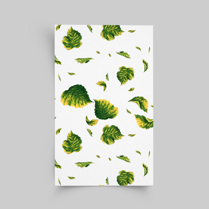 Notebook with green leaf pattern on a white cover against a gray background