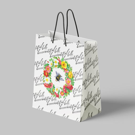 Gift bag with floral design and text on a gray background