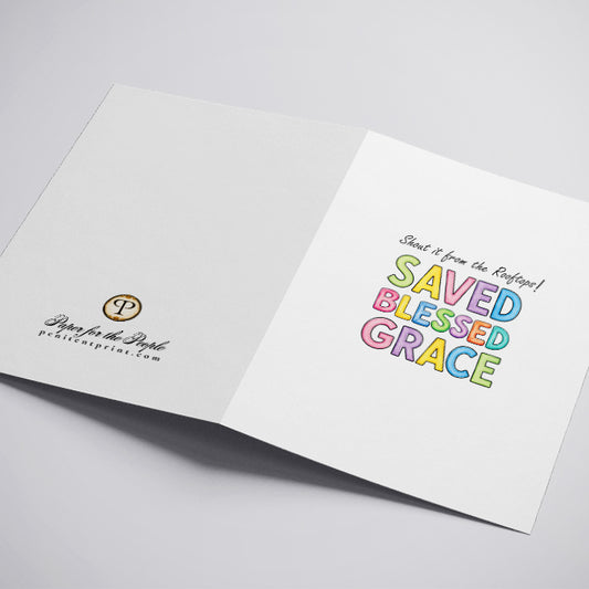 A white greeting card with the text 'Shout it from the Rooftops! SAVED BLESSED GRACE' in colorful pastel letters.