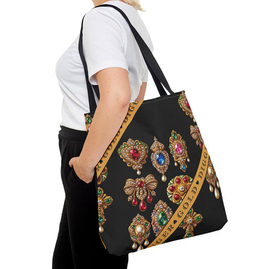 Black tote bag with decorative brooches and 'Gold Digger' text held by a person.