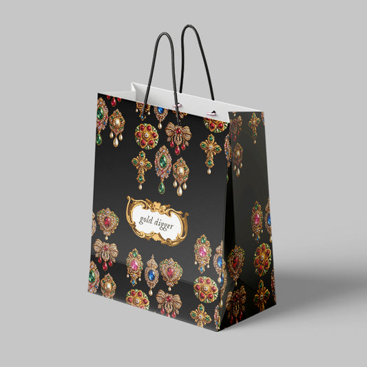 Black large paper gift bag with jewelry-themed design and 'gold digger' text on a gray background