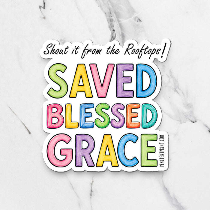 A die-cut vinyl sticker with the text 'Shout it from the Rooftops! SAVED BLESSED GRACE' in colorful pastel letters, displayed on a white marble background.