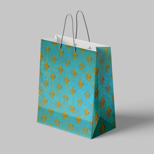 Teal paper bag with gold fleur-de-lis pattern on a gray background