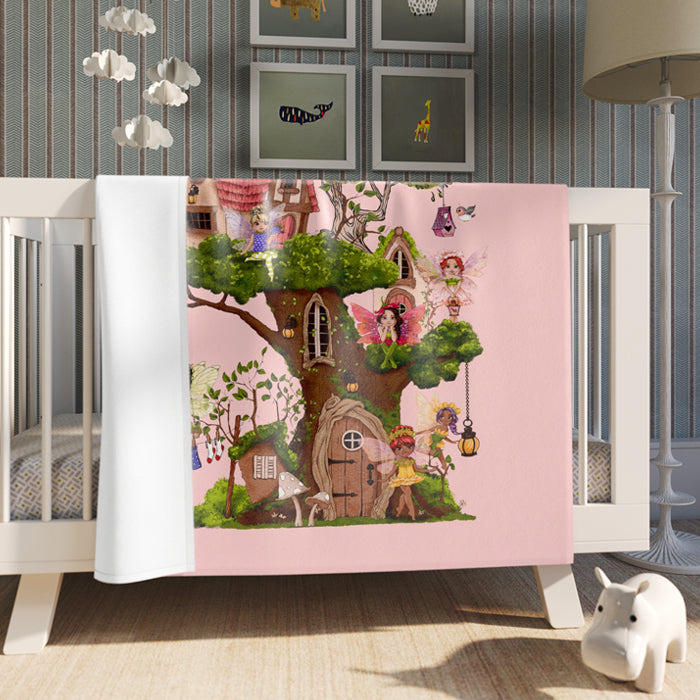Children's blanket with fairy tale design draped over a crib in a nursery.