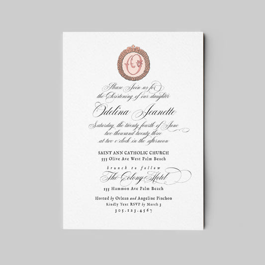A vertical white invitation card with elegant black script text and a small oval family portrait in a pinkish ornate frame near the top, shown centered on a light gray background.