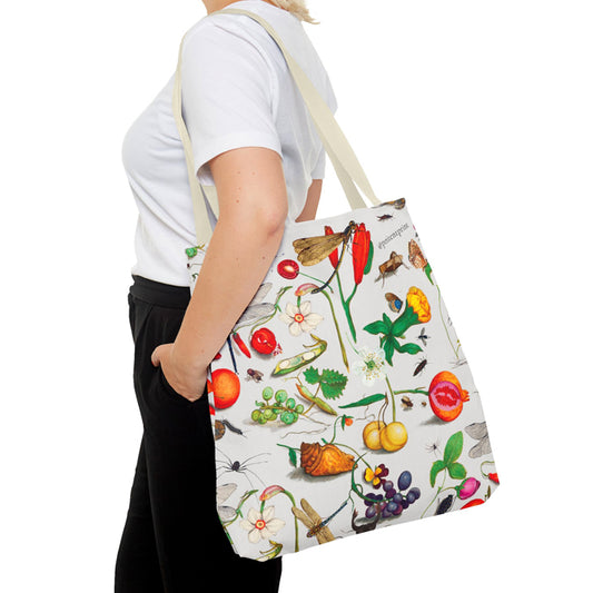 Person holding a tote bag with nature-themed design on a white background