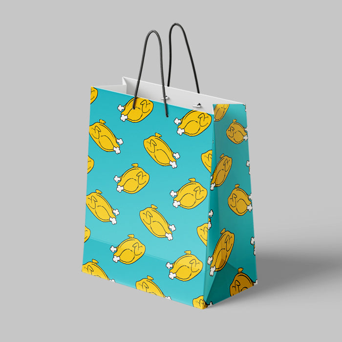 Matte blue paper bag with yellow chicken illustrations on a gray background