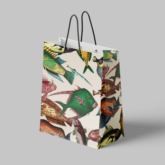 A large, rectangular gift bag with black twisted handles, featuring a colorful, antique fish illustration pattern